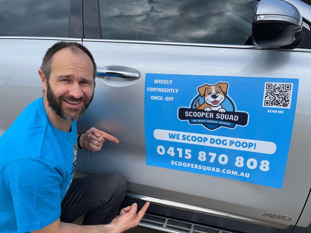 Scooper Squad owner Dan beside car door sign promoting dog waste removal service